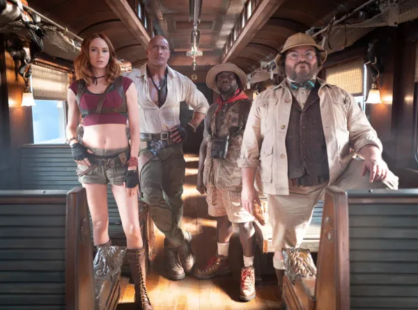 Dwayne Johnson, Karen Gillan, Kevin Hart and Jack Black in their game-avatar costumes aboard a train car in Jumanji: Open World