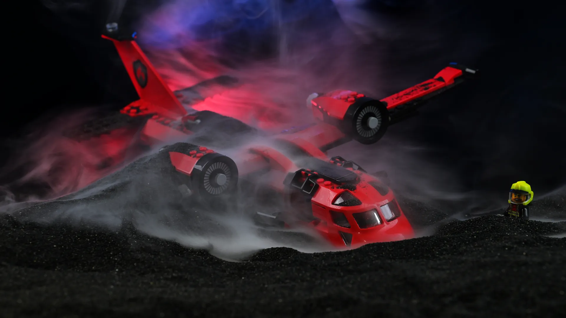The LEGO City Fire Rescue Plane (60413) resting on black slag in dramatic smoke with a firefighter minifigure in yellow helmet watching