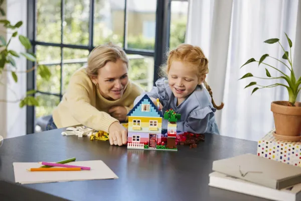 Kids building LEGO sets together at a table - official LEGO lifestyle photo