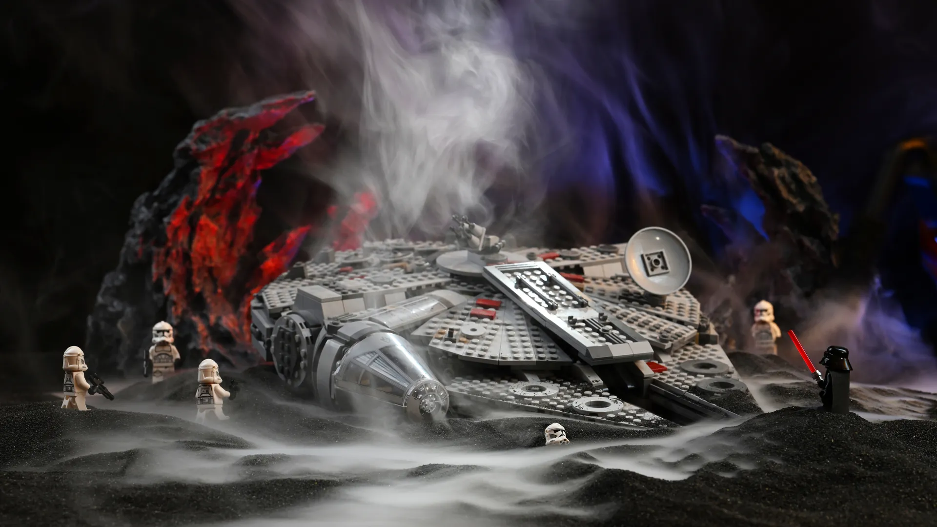 The fully built LEGO Millennium Falcon (75257) surrounded by Darth Vader and clone troopers in drifting smoke on a black slag diorama stage